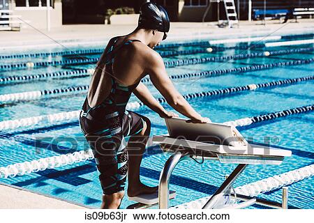 Swimmer getting onto pool diving board View Large Photo Image Stock Photography - Swimmer getting onto pool diving board. Fotosearch