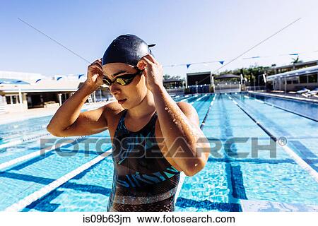 Swimmer in swimming cap and goggles by pool View Large Photo Image Picture - Swimmer in swimming cap and goggles by pool. Fotosearch