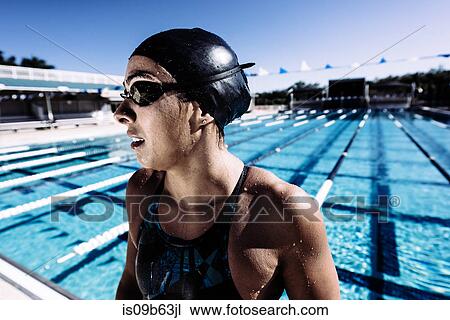 Swimmer in swimming cap and goggles catching breath by pool View Large Photo Image Stock Image - Swimmer in swimming cap and goggles catching breath by pool. Fotosearch