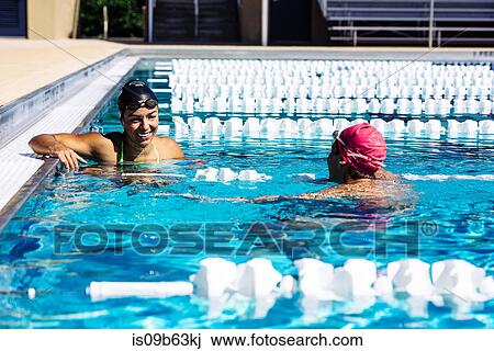 Swimmer in water at end of pool talking to friend View Large Photo Image Stock Image - Swimmer in water at end of pool talking to friend. Fotosearch