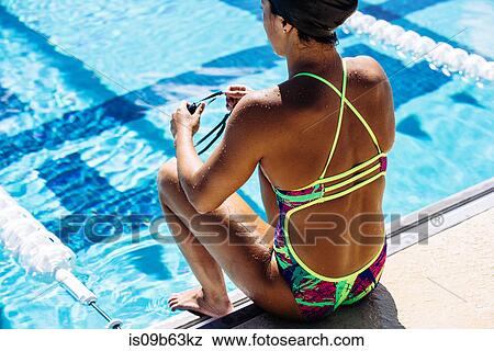 Stock Photo - Swimmer sitting at end of pool. Fotosearch