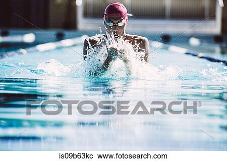 Stock Image - Swimmer splashing pool water on face. Fotosearch