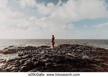 Swimmer standing on rocks by sea, Princeville, Hawaii, US View Large Photo Image Stock Image - Swimmer standing on rocks by sea, Princeville, Hawaii, US. Fotosearch