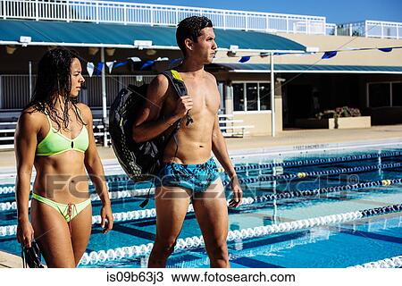 Stock Image - Swimmers walking by pool. Fotosearch