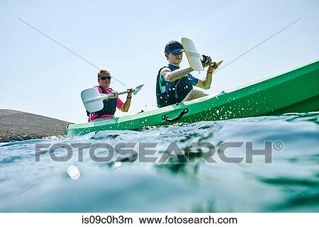 Teenage boy and mother sea kayaking, surface level side view, Limnos, Khios, Greece View Large Photo Image Picture - Teenage boy and mother sea kayaking, surface level side view, Limnos, Khios, Greece. Fotosearch