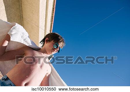 Teenage boy with wet hair wrapping towel around shoulders at hotel poolside, low angle view, Las Vegas, Nevada, USA View Large Photo Image Stock Image - Teenage boy with wet hair wrapping towel around shoulders at hotel poolside, low angle view, Las Vegas, Nevada, USA. Fotosearch