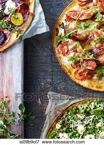 Stock Photo - Three fresh pizzas, cropped overhead view. Fotosearch