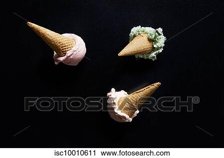 Three ice-cream cones, mint, chocolate chip and strawberry against black background, overhead view View Large Photo Image Stock Image - Three ice-cream cones, mint, chocolate chip and strawberry against black background, overhead view. Fotosearch