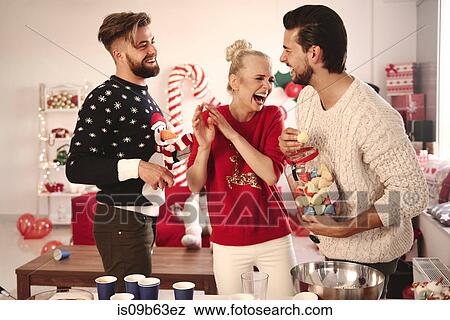 Three young friends laughing at christmas party View Large Photo Image Stock Photo - Three young friends laughing at christmas party. Fotosearch
