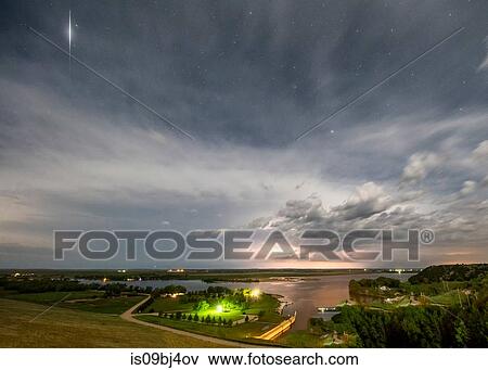 Thunderstorm roars in the distance while a satellite flashes light off its solar panels over rural Nebraska, US View Large Photo Image Stock Photo - Thunderstorm roars in the distance while a satellite flashes light off its solar panels over rural Nebraska, US. Fotosearch
