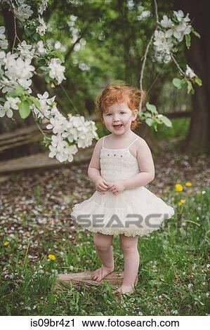 Stock Image - Toddler in tutu by blossom tree. Fotosearch