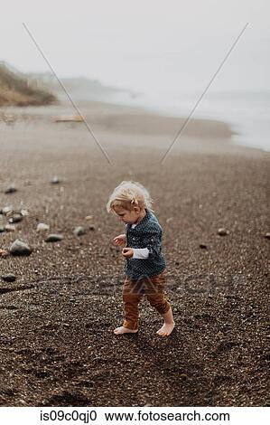 Toddler playing on beach View Large Photo Image Stock Image - Toddler playing on beach. Fotosearch