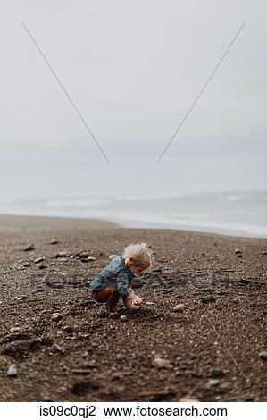 Toddler playing on beach View Large Photo Image Stock Image - Toddler playing on beach. Fotosearch