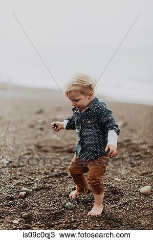 Toddler playing on beach View Large Photo Image Stock Image - Toddler playing on beach. Fotosearch