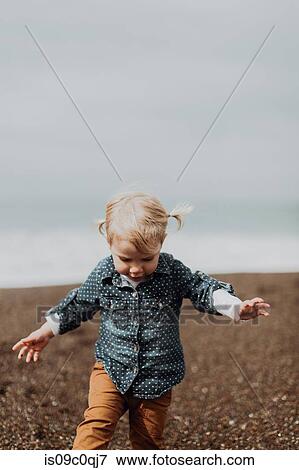 Toddler playing on beach View Large Photo Image Stock Photo - Toddler playing on beach. Fotosearch