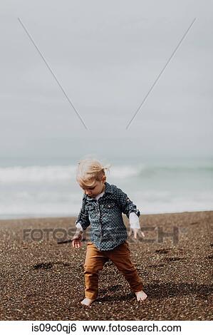 Toddler playing on beach View Large Photo Image Stock Photograph - Toddler playing on beach. Fotosearch