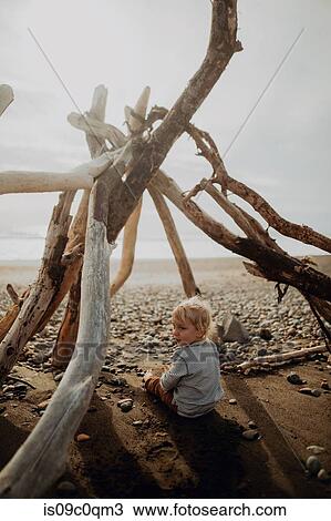 Toddler sitting inside wickiup on beach View Large Photo Image Stock Image - Toddler sitting inside wickiup on beach. Fotosearch
