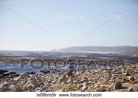 Tourist looking at stone cairn on beach, Cape Town, Western Cape, South Africa View Large Photo Image Stock Photography - Tourist looking at stone cairn on beach, Cape Town, Western Cape, South Africa. Fotosearch