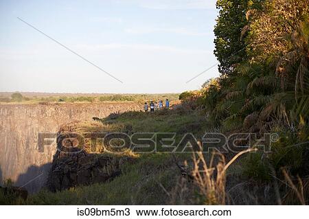 Tourists on cliff top, Victoria Falls, Zimbabwe View Large Photo Image Stock Image - Tourists on cliff top, Victoria Falls, Zimbabwe. Fotosearch