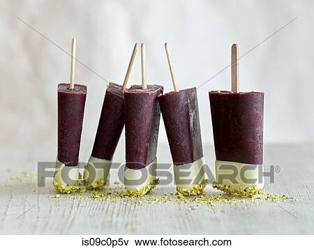 Tri-coloured ice lollies in a row on table, white background View Large Photo Image Stock Photo - Tri-coloured ice lollies in a row on table, white background. Fotosearch