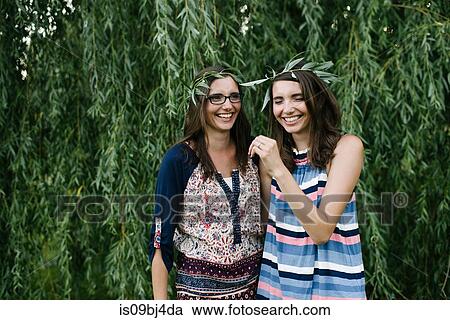 Twin sisters beside weeping willow branches View Large Photo Image Stock Image - Twin sisters beside weeping willow branches. Fotosearch