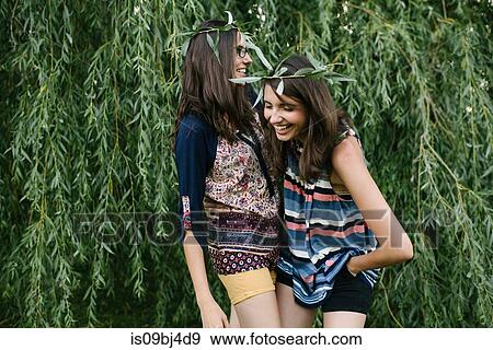 Stock Photo - Twin sisters beside weeping willow branches. Fotosearch