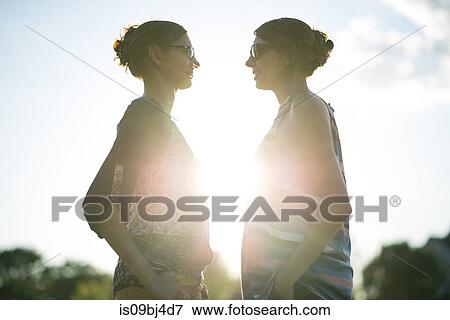 Twin sisters in park at sunset View Large Photo Image Stock Photo - Twin sisters in park at sunset. Fotosearch