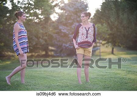 Twin sisters in park at sunset View Large Photo Image Stock Photograph - Twin sisters in park at sunset. Fotosearch
