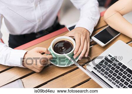 Two businesspeople, having meeting at cafe, using laptop, mid section View Large Photo Image Stock Photograph - Two businesspeople, having meeting at cafe, using laptop, mid section. Fotosearch