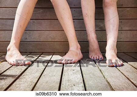 Two girls standing barefoot, view of legs View Large Photo Image Stock Image - Two girls standing barefoot, view of legs. Fotosearch