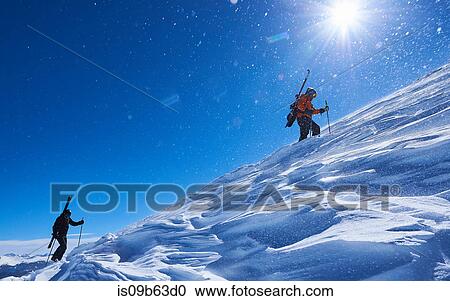 Two male skiers trudging up snow covered mountain, Aspen, Colorado, USA View Large Photo Image Stock Image - Two male skiers trudging up snow covered mountain, Aspen, Colorado, USA. Fotosearch