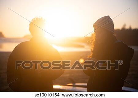Two mid adult female friends on coast at sunset, Tofino, Vancouver Island, Canada View Large Photo Image Picture - Two mid adult female friends on coast at sunset, Tofino, Vancouver Island, Canada. Fotosearch