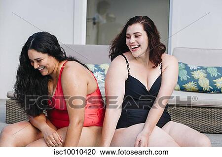Two mid adult women sitting on outdoor poolside laughing together, Cape Town, South Africa View Large Photo Image Stock Image - Two mid adult women sitting on outdoor poolside laughing together, Cape Town, South Africa. Fotosearch