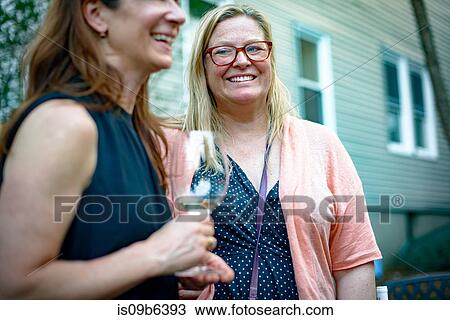 Two women at garden party, in conversation View Large Photo Image Stock Image - Two women at garden party, in conversation. Fotosearch