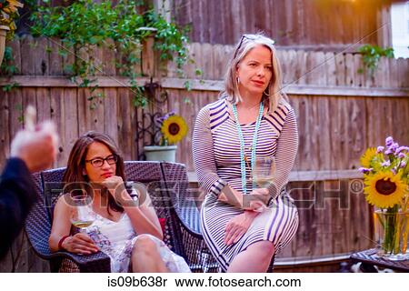 Two women at garden party, sitting, in conversation View Large Photo Image Stock Photography - Two women at garden party, sitting, in conversation. Fotosearch