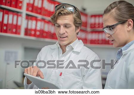 Two workers in thread factory, looking at digital tablet View Large Photo Image Stock Image - Two workers in thread factory, looking at digital tablet. Fotosearch