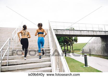 Stock Photo - Two you women exercising outdoors, running up steps, rear view, steps, South Point Park, Miami Beach, Florida, USA. Fotosearch