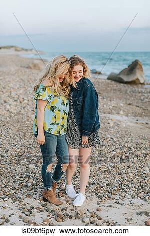 Stock Photo - Two young women hugging on beach, Menemsha, Martha's Vineyard, Massachusetts, USA. Fotosearch