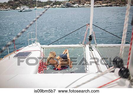 Two young women relaxing on sailing boat, British Virgin Islands View Large Photo Image Stock Photo - Two young women relaxing on sailing boat, British Virgin Islands. Fotosearch