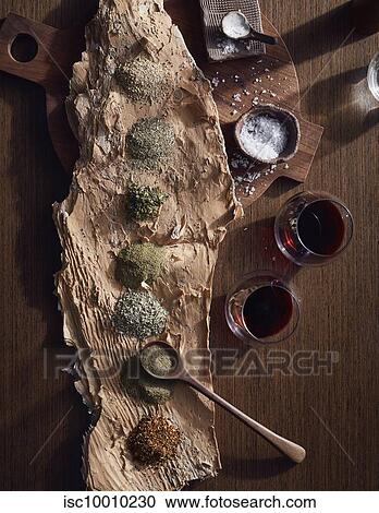 Stock Image - Variety of bush spices on log platter, a bush tucker dish using indigenous ingredients. Fotosearch