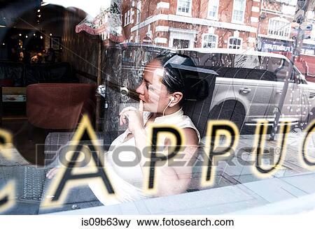 View through window of businesswoman working in coffee bar View Large Photo Image Stock Photo - View through window of businesswoman working in coffee bar. Fotosearch