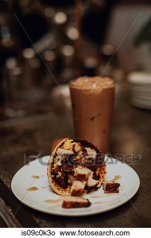 Waffle cone and glass of iced coffee on cafe table, shallow focus close up View Large Photo Image Picture - Waffle cone and glass of iced coffee on cafe table, shallow focus close up. Fotosearch