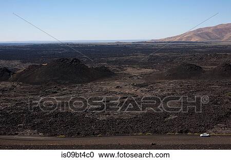 White car driving on a road at the Craters of the Moon National Monument and 0eserve, Arco, Idaho, USA View Large Photo Image Stock Image - White car driving on a road at the Craters of the Moon National Monument and 0eserve, Arco, Idaho, USA. Fotosearch
