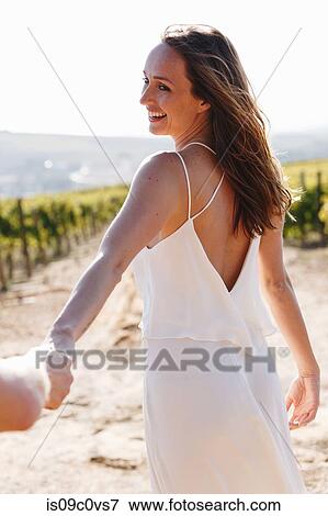 Stock Photo - Woman and man walking in vineyards, Cape Town South Africa. Fotosearch