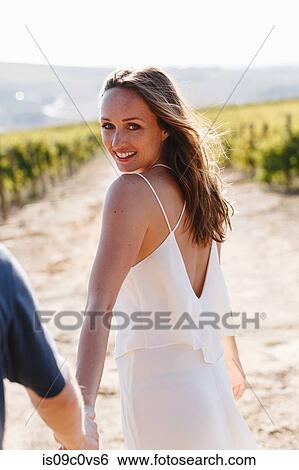 Stock Photograph - Woman and man walking in vineyards, Cape Town South Africa. Fotosearch