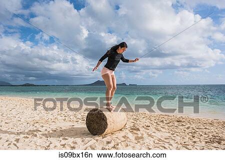 Woman balancing on grass roll, Lanikai Beach, Oahu, Hawaii View Large Photo Image Picture - Woman balancing on grass roll, Lanikai Beach, Oahu, Hawaii. Fotosearch