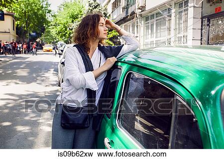 Stock Photo - Woman beside green car. Fotosearch