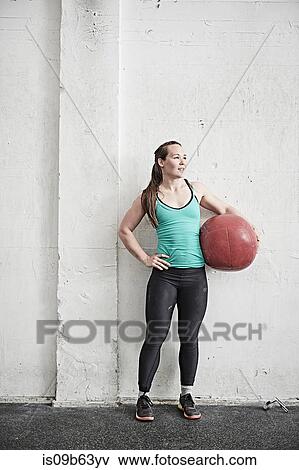 Woman carrying fitness ball in cross training gym View Large Photo Image Stock Photo - Woman carrying fitness ball in cross training gym. Fotosearch