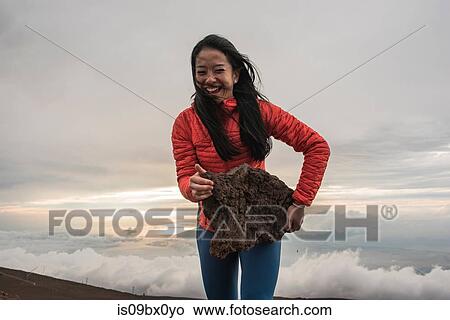 Woman carrying large rock on edge of mountain, Haleakala National Park, Maui, Hawaii View Large Photo Image Picture - Woman carrying large rock on edge of mountain, Haleakala National Park, Maui, Hawaii. Fotosearch