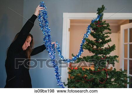 Woman decorating Christmas tree View Large Photo Image Stock Photo - Woman decorating Christmas tree. Fotosearch